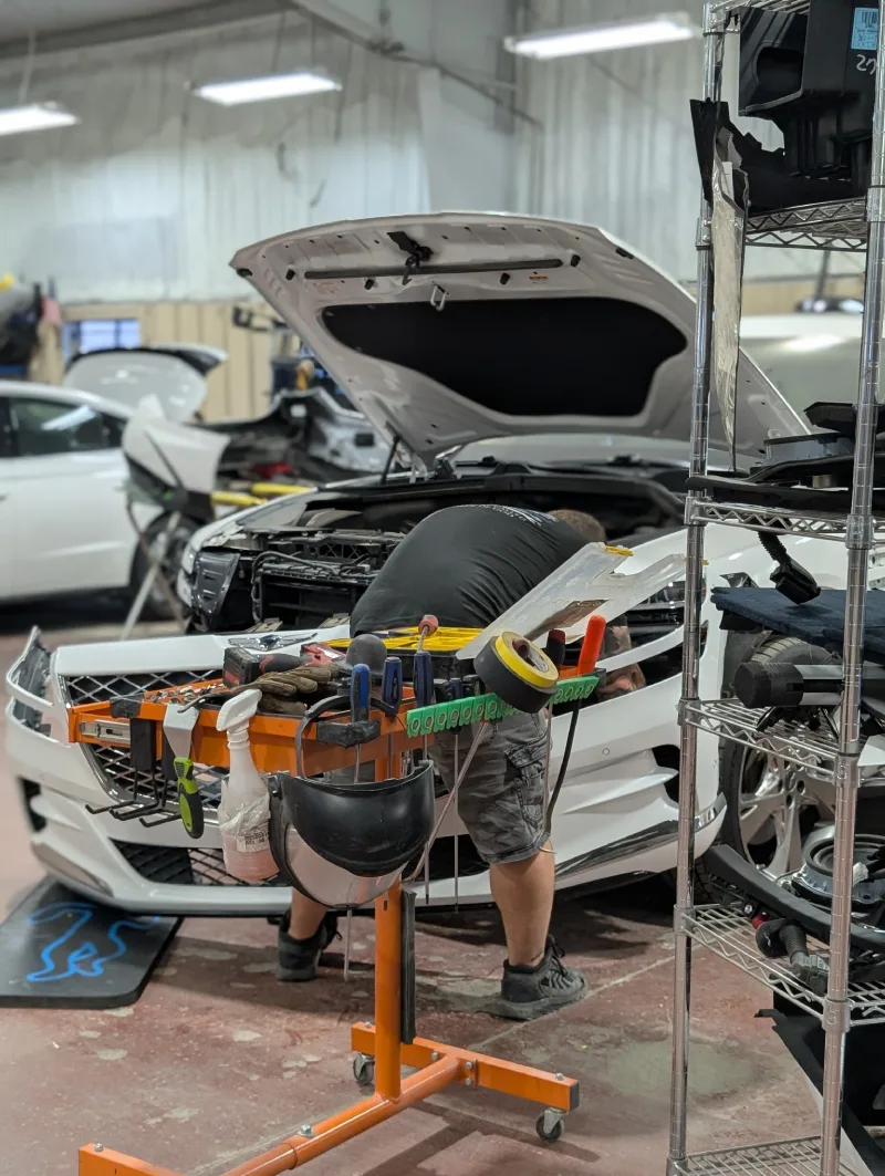 McCarthy Collision Center: A technician replacing the front bumper