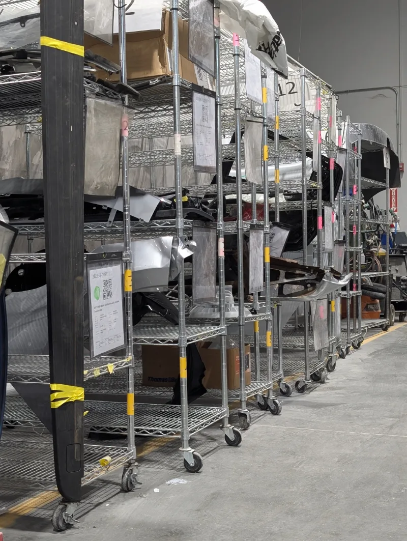 McCarthy Collision Center: A truck with its hood open and a technician grabbing parts from a shelf