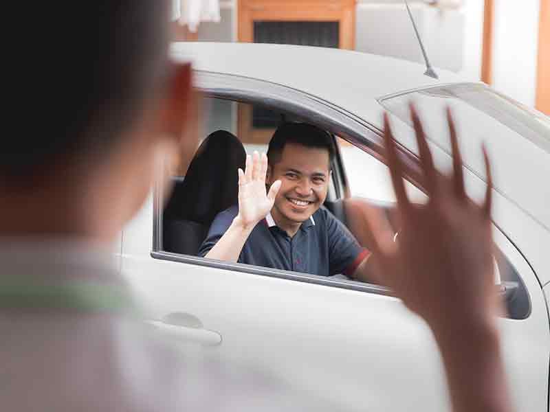 McCarthy Collision Center in Olathe KS customer waving at technician